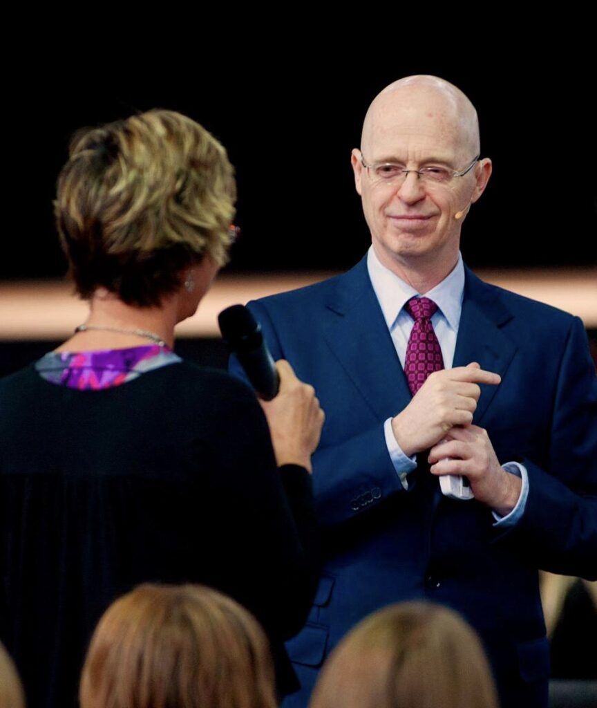 photo of Joshua with a lady on the mic.